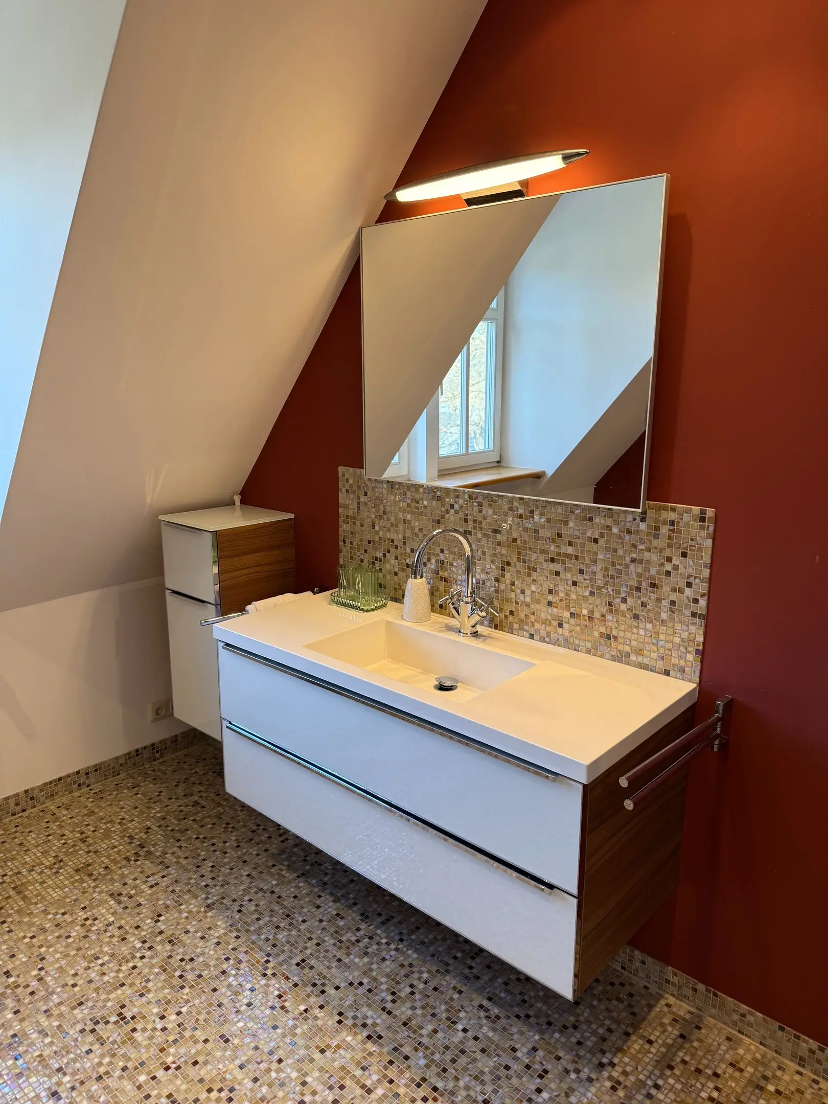 Waschtisch mit Spiegel vor dunkelroter Wand