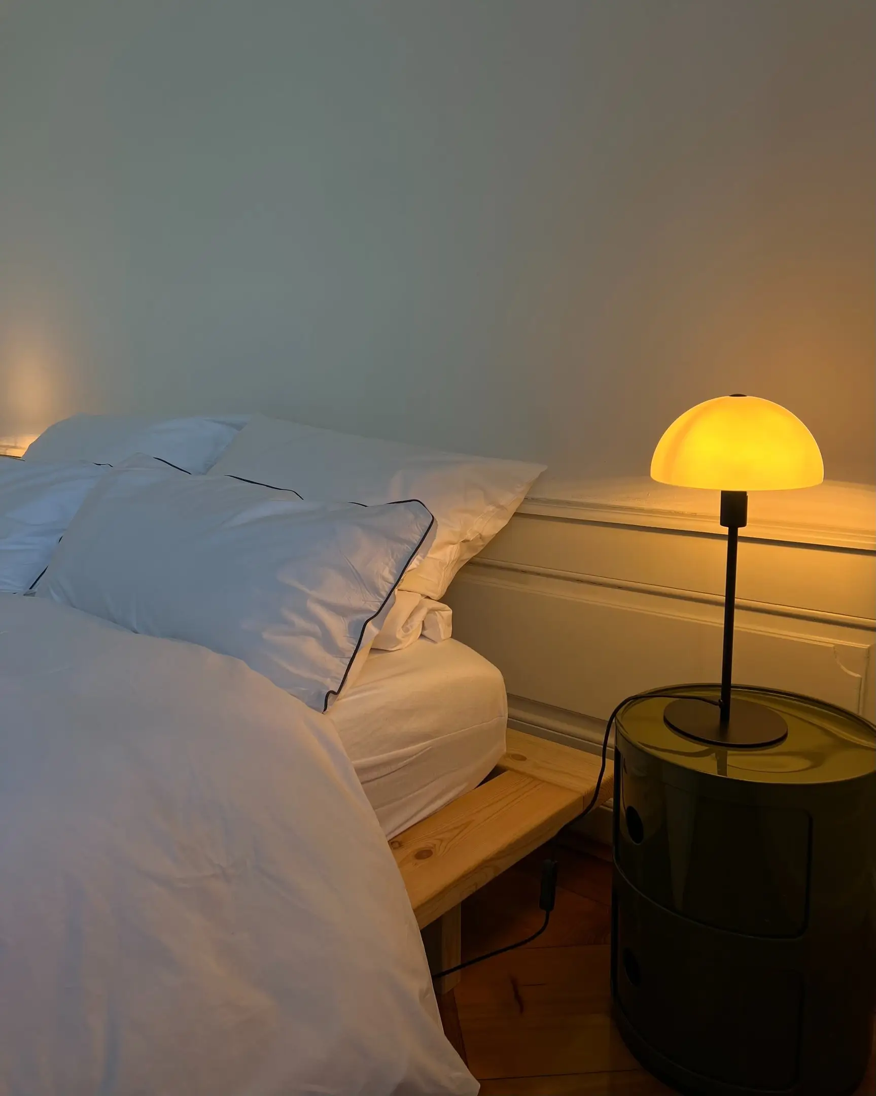 Bett mit Nachttischleuchte im warmen Licht
