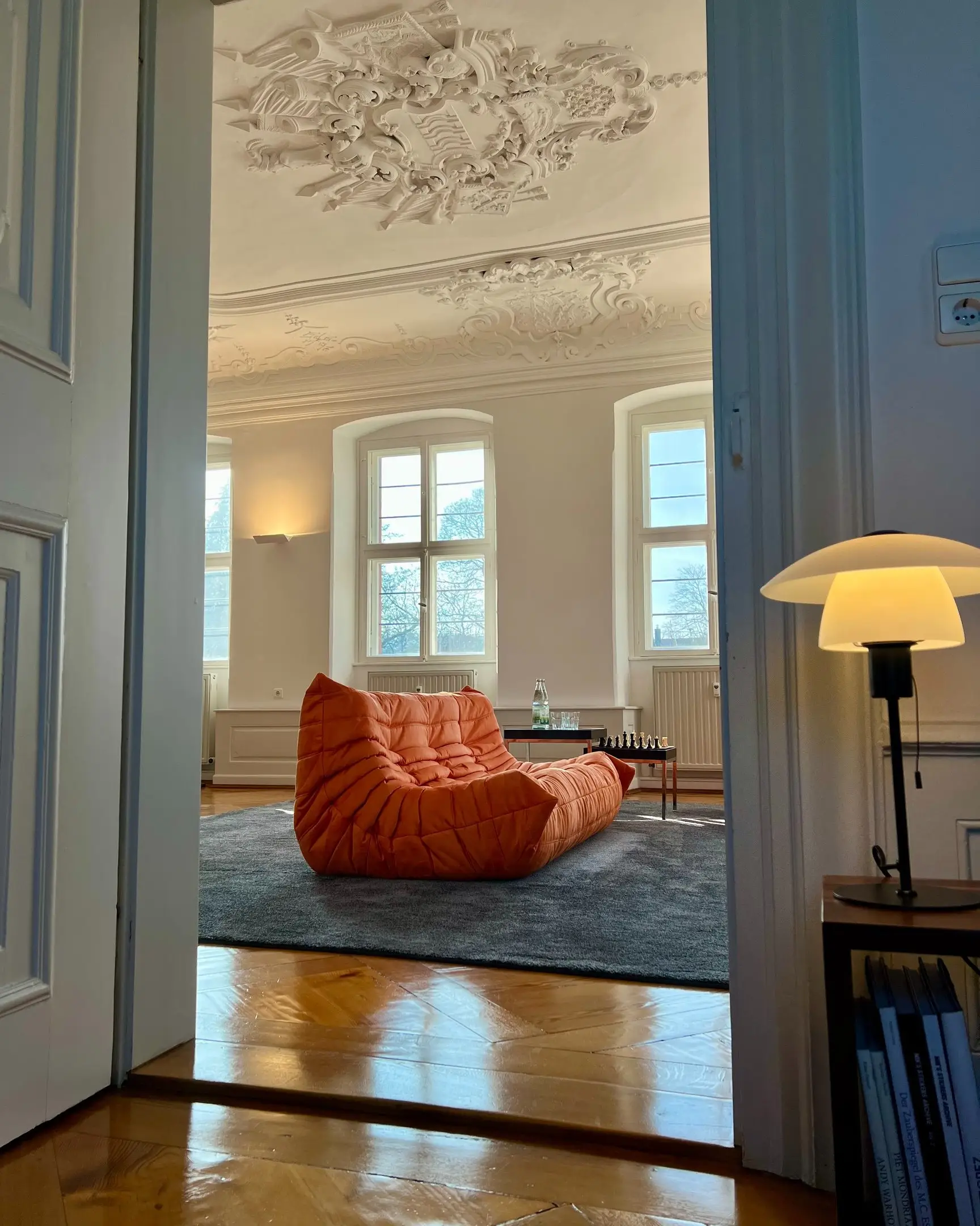 Blick durch die Flügeltür in den Salon mit Stuckdecke
