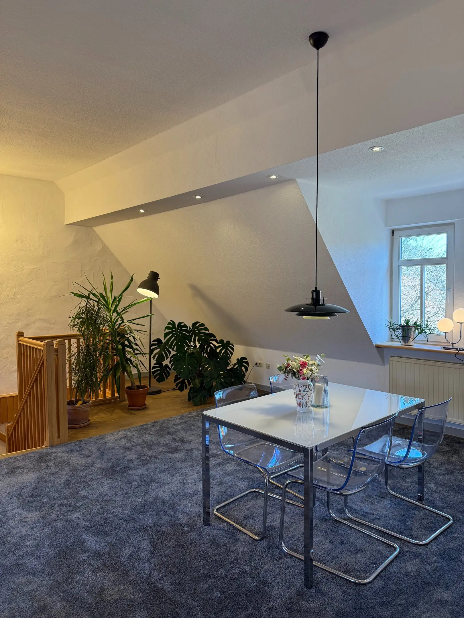 Glasesstisch mit Freischwingern, dahinter die Treppe