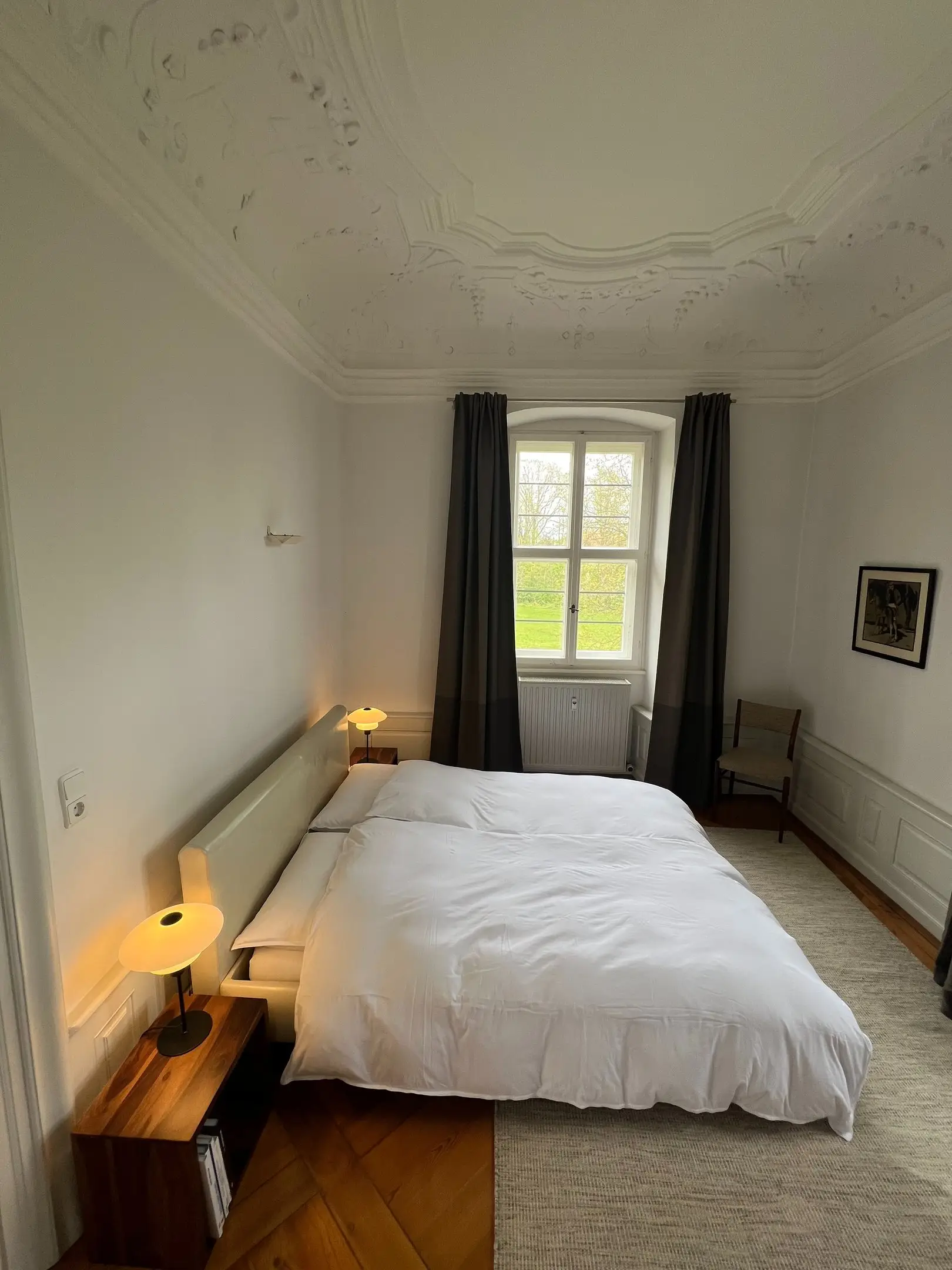 Schlafzimmer mit Stuckdecke und Blick ins Grüne