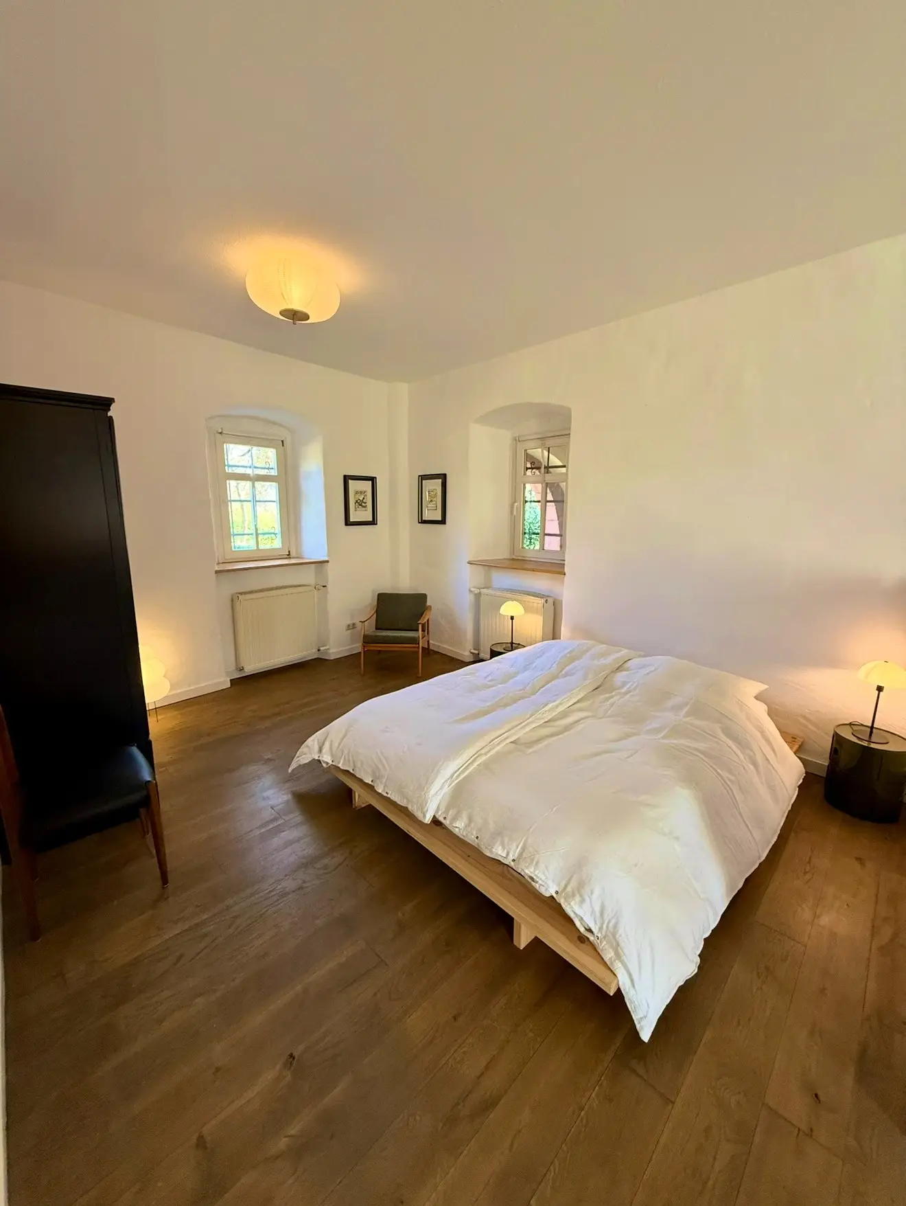Helles Schlafzimmer mit Holzboden und Doppelbett