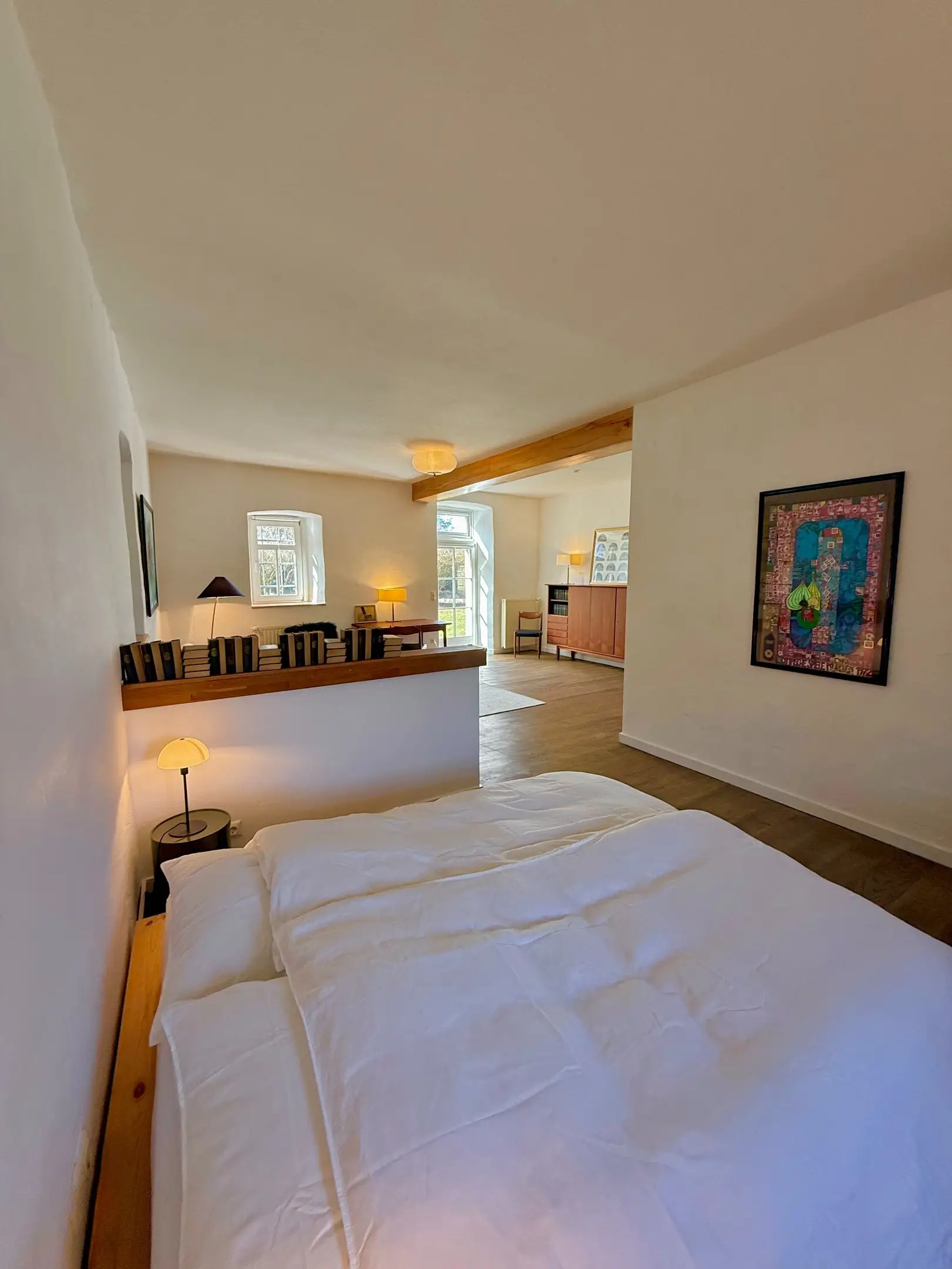 Bett mit Blick in den Wohnbereich