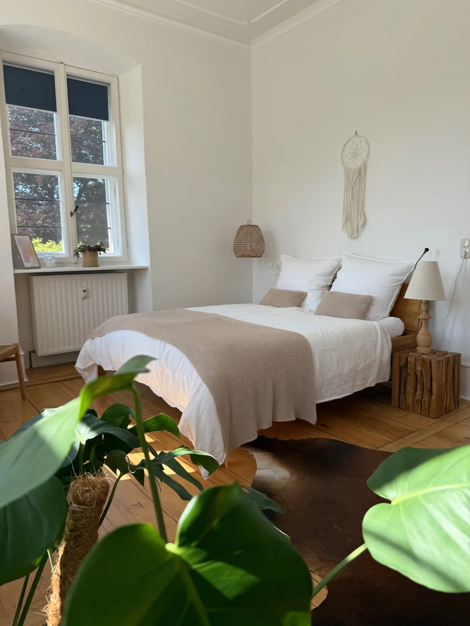Schlafzimmer mit Doppelbett, Fell und Monstera