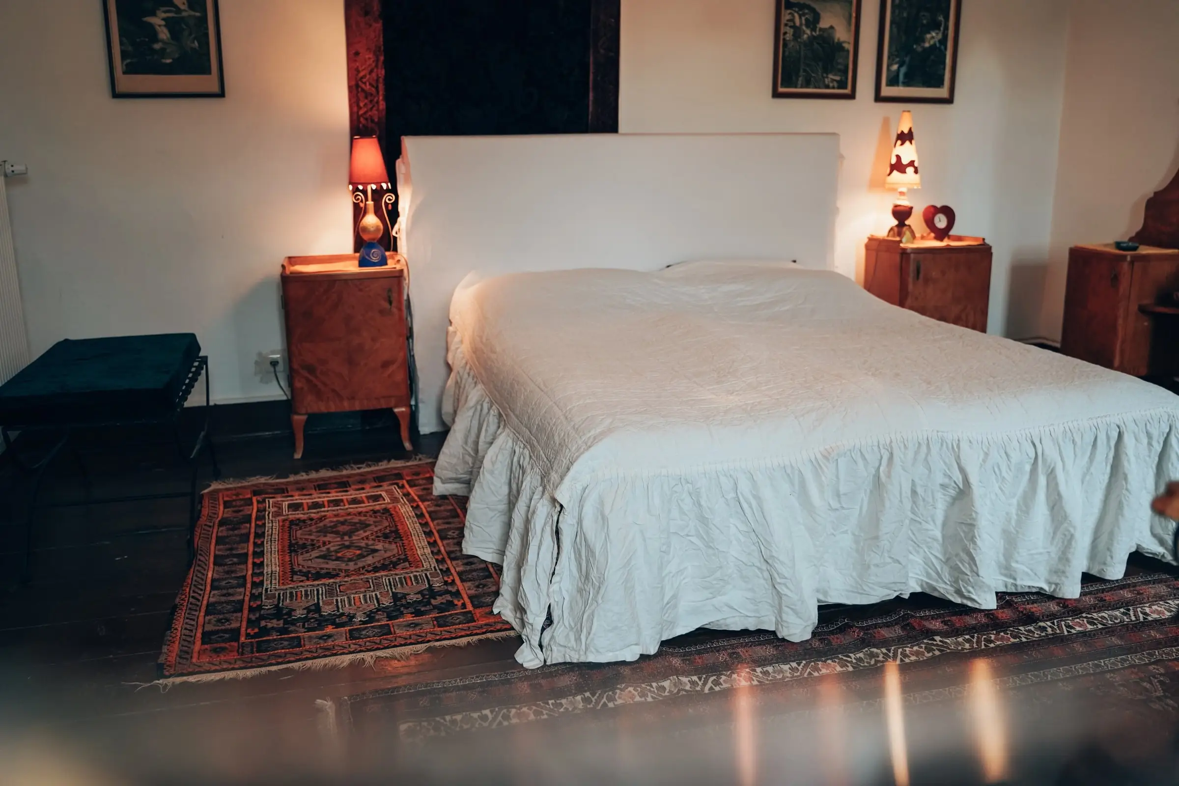 Schlafzimmer mit weißer Tagesdecke, Orientteppich und Nachttischlampen