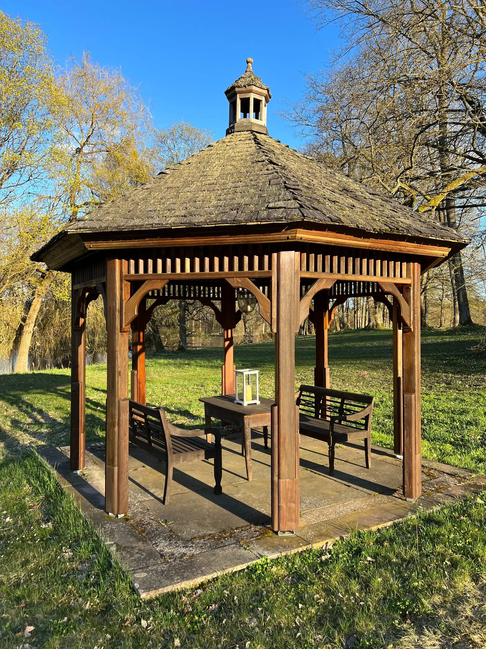 Hölzerner Teepavillon mit Sitzbänken im Schlosspark