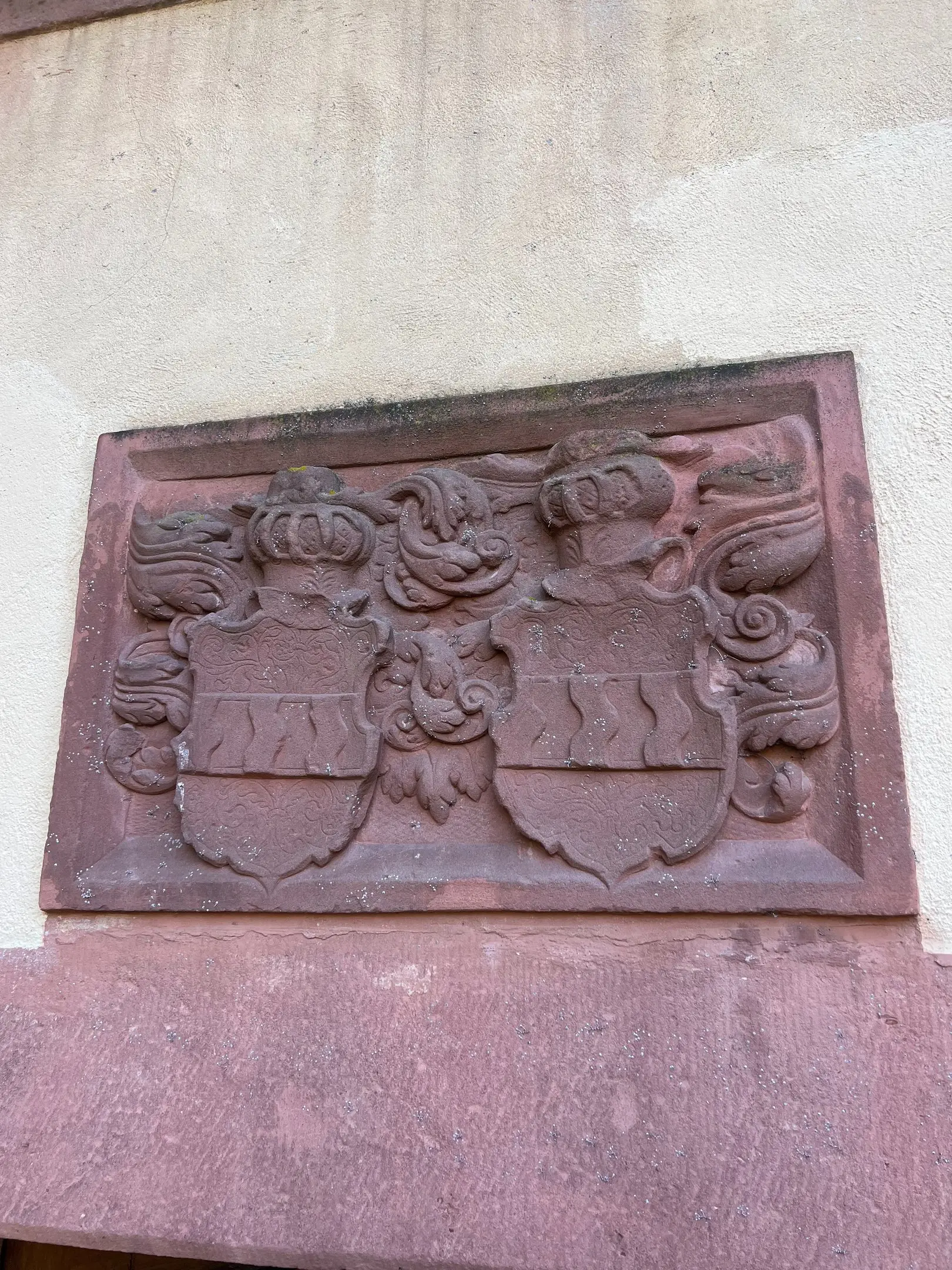 Wappenstein aus rotem Sandstein an der Schlossmauer