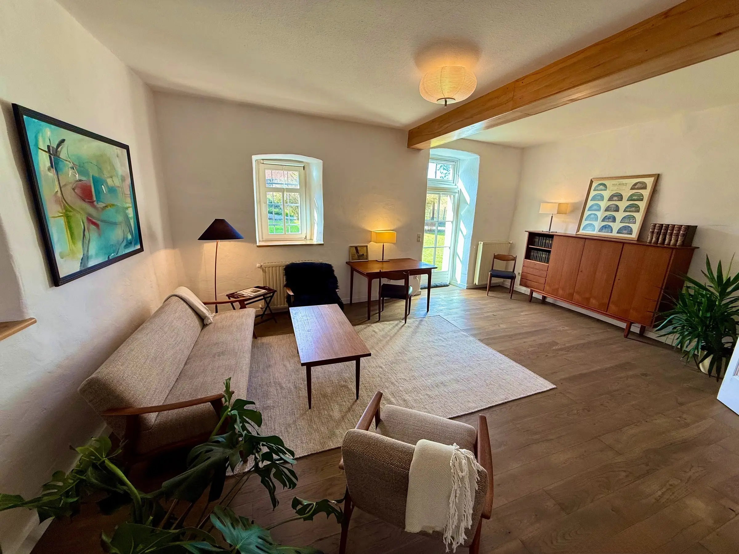Zweites Wohnzimmer mit Holzbalken, Sofa und Sideboard