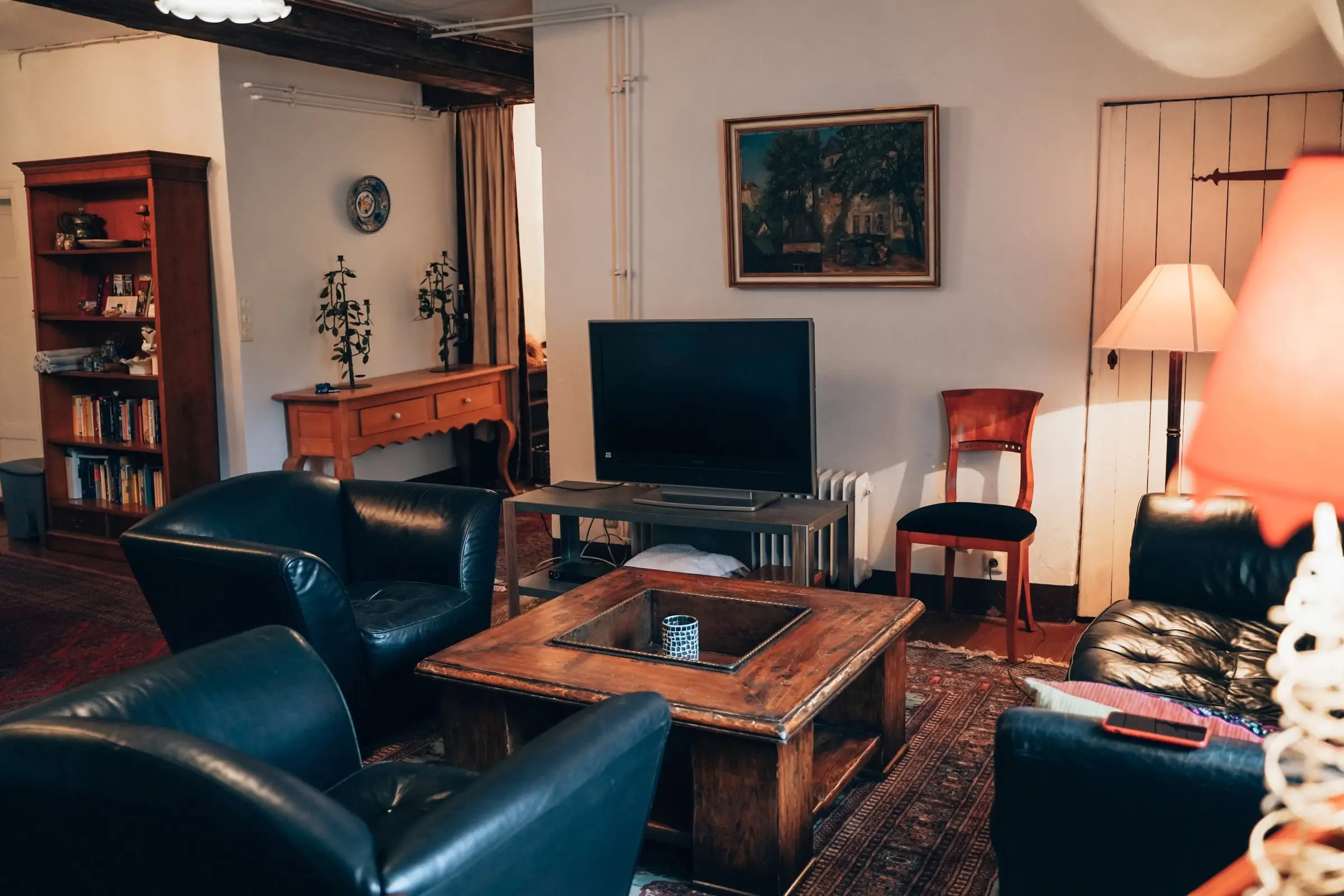 Wohnbereich mit Ledersesseln, Bücherregal und Fernseher